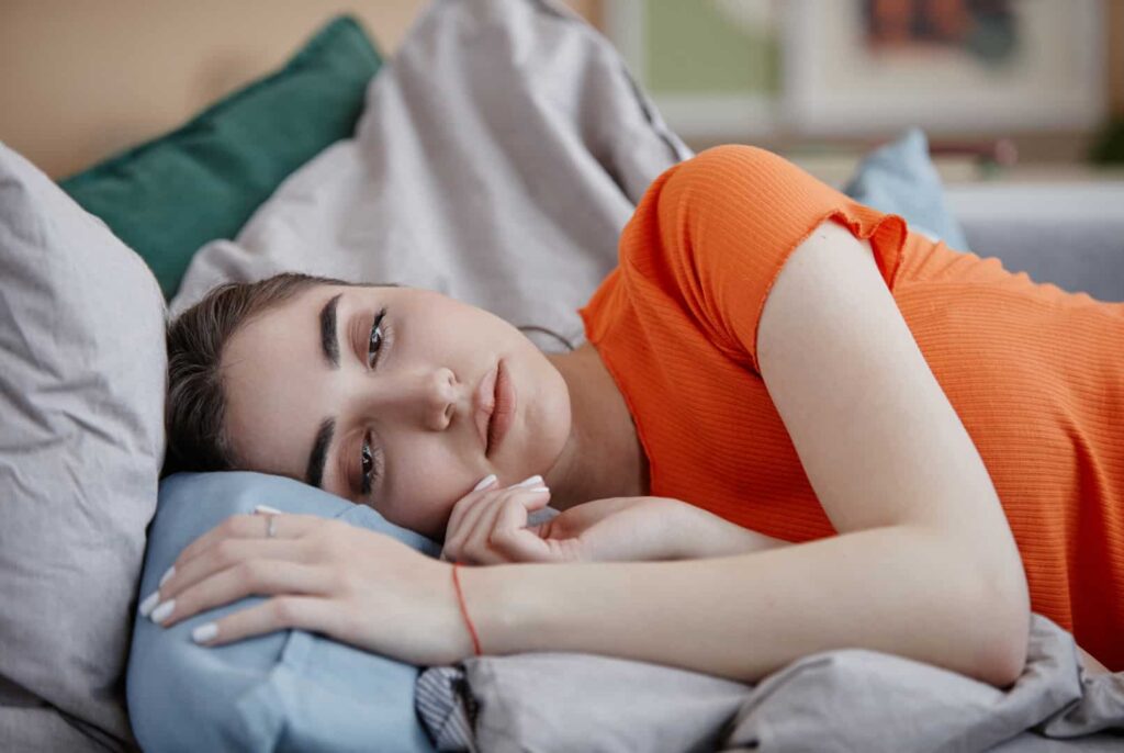Terapia depresji - przygnębiona kobieta leżąca w łóżku